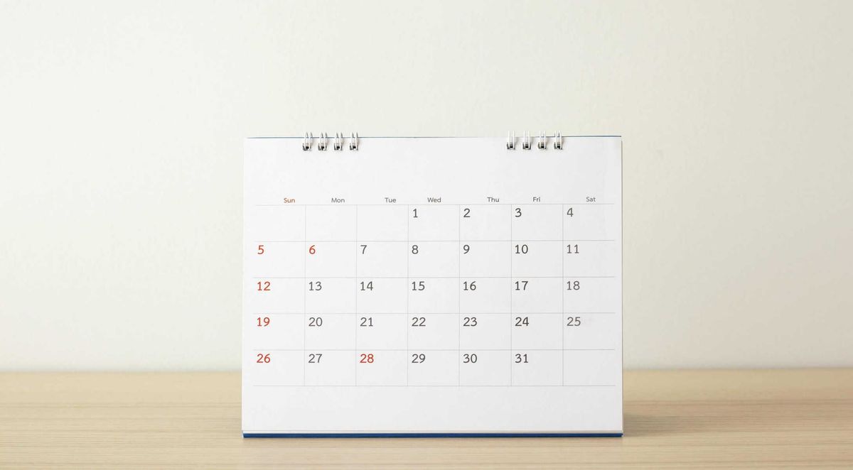 calendar page close up wood table with white wall background business planning appointment meeting concept scaled